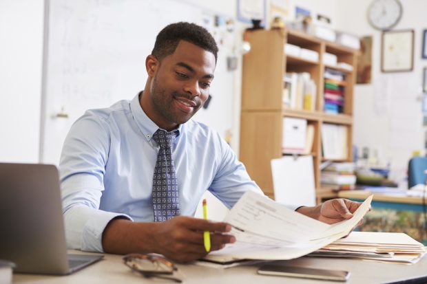 African American male teacher working at his desk