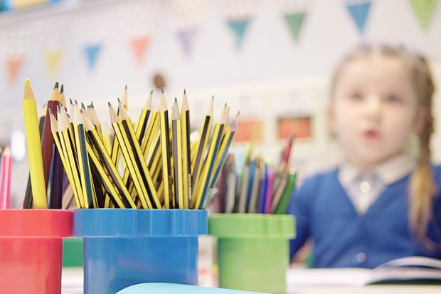 A child looking at a bunch of pencils - bought with school funding